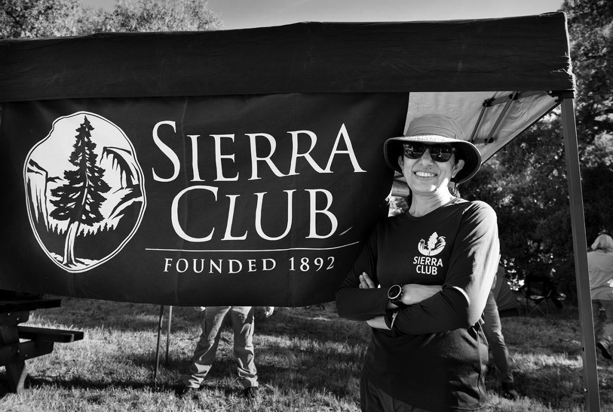 Tejinder Dhillon poses in front of Sierra Club banner