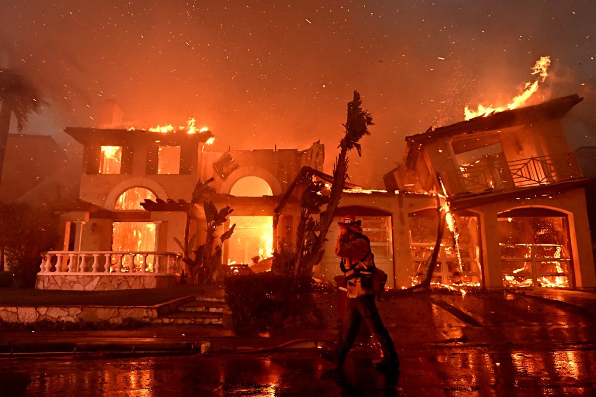A firefighter walks past burning homes at Coronado Pointe in Laguna Niguel.(Wally Skalij / Los Angeles Times)