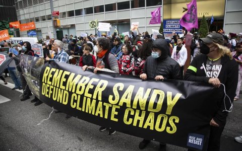 Protestors gather around a sign