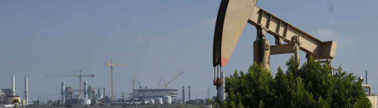 An oil pumpjack steals the scene with new power plant construction in the background. Los Cerritos W