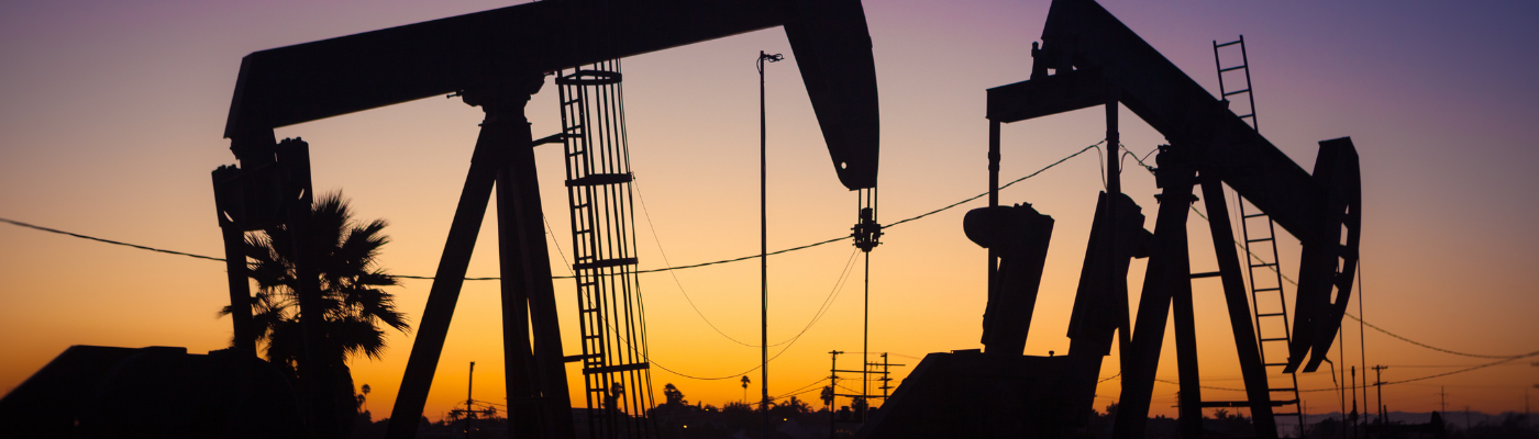 The sun setting on an oil field