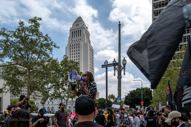 Woman speaks into megaphone at protest outside LA City Hall, June '20